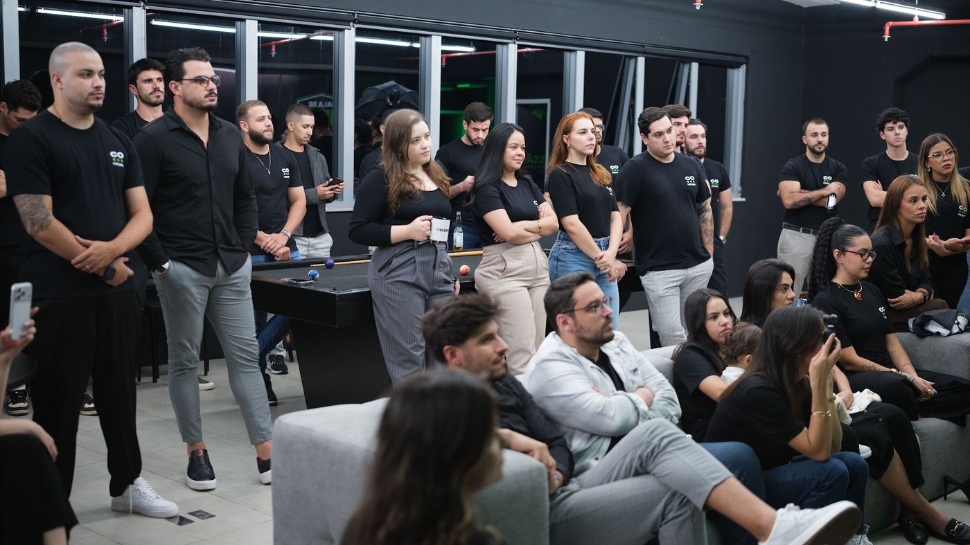 Escritório da Coders em Florianópolis: o time reunido na área de trabalho, com bancadas e mesa de sinuca ao fundo.